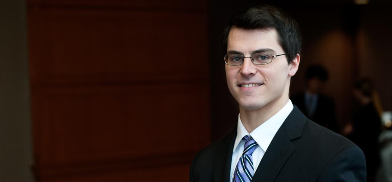 Business student wearing a suit and tie poses for a portrait