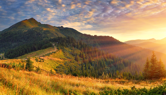 Sun setting over mountain scene