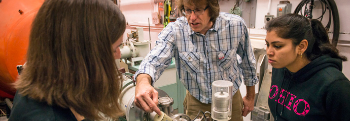 Graduate students Cody Parker and Shamim Akhtar with Dr. Carl Brune in the Edwards Accelerator Lab.