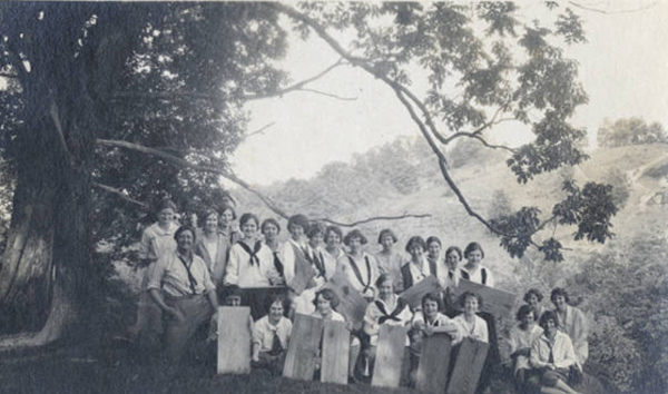 Irma Voigt, Ohio University dean of women (at left), poses for group photograph with large crowd of students on hillside, circa 1920s-1930s