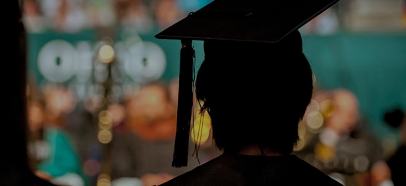 A graduate in academia regalia in profile.