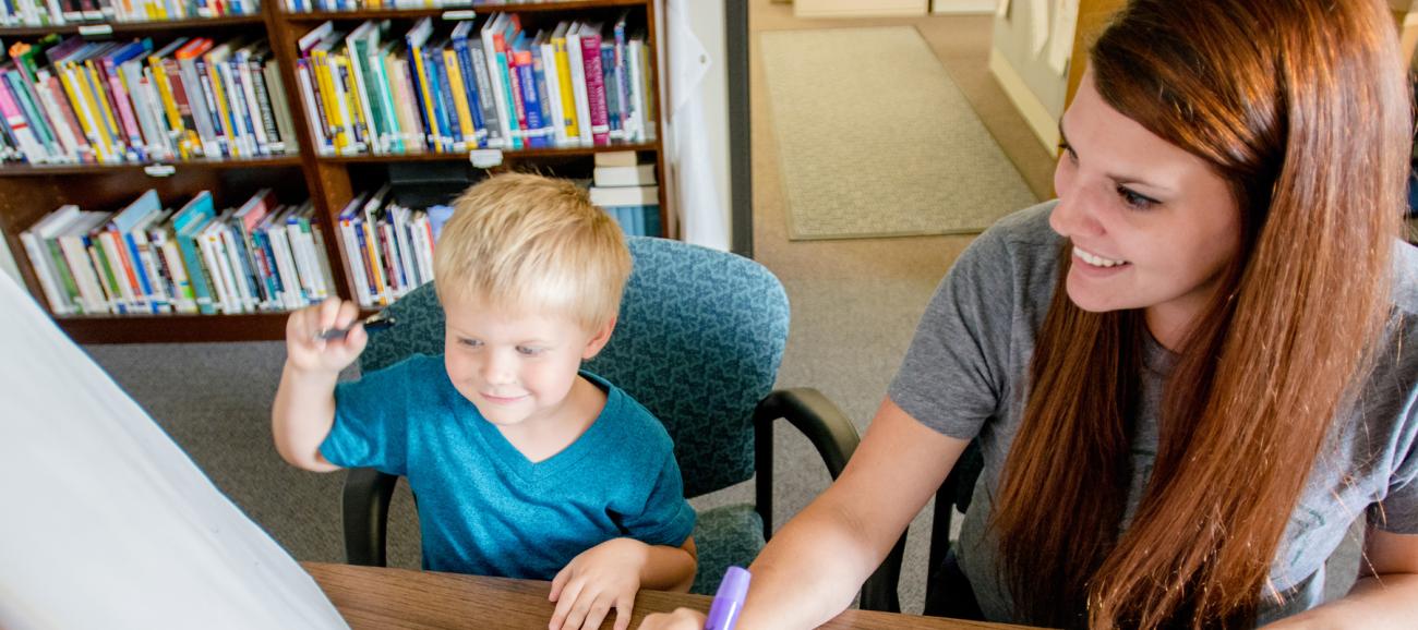 Child counseling social work setting with small child, markers and paper