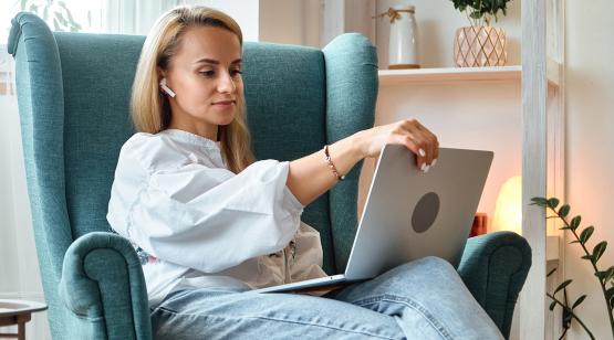 Woman sitting at a laptop on a chair