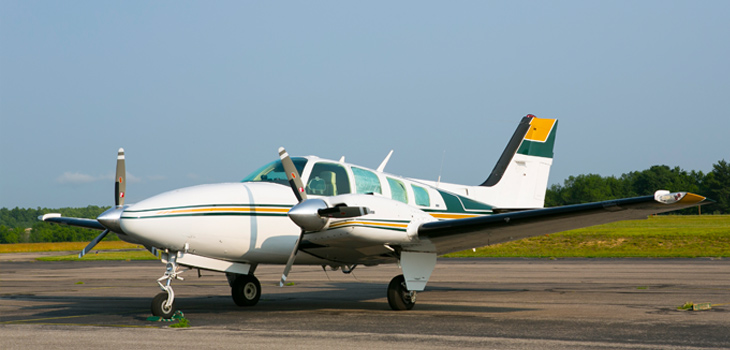 Beechcraft Baron 58 parked on landing strip