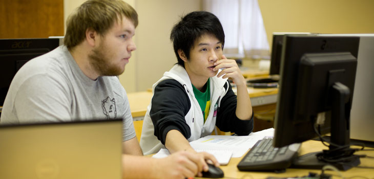 Two men looking at a computer monitor