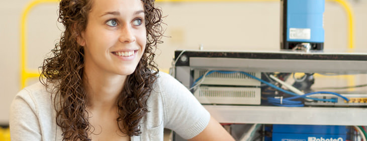 Woman in lab looking off to the side and smiling