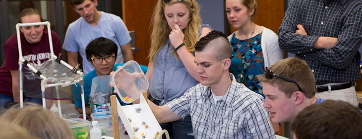 Students gathered around lab equipment