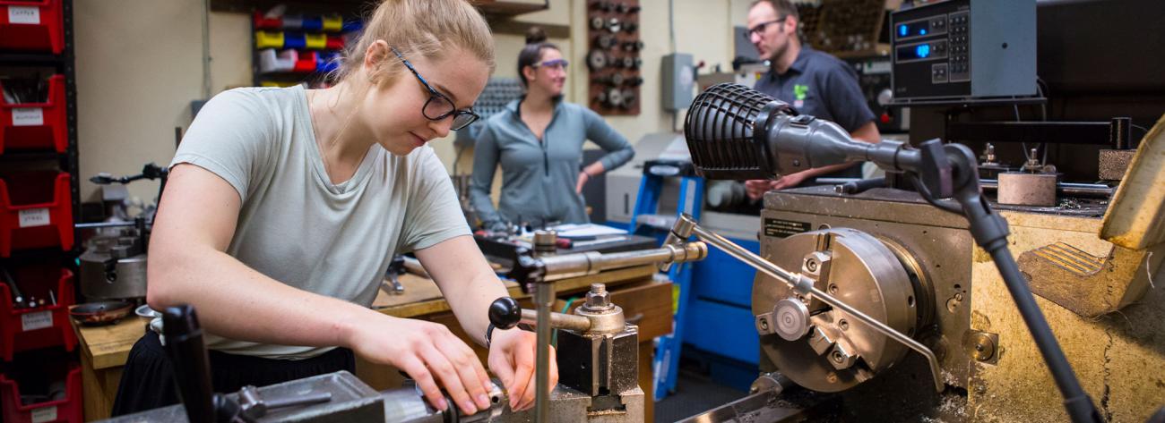 A young woman working in a machine shop