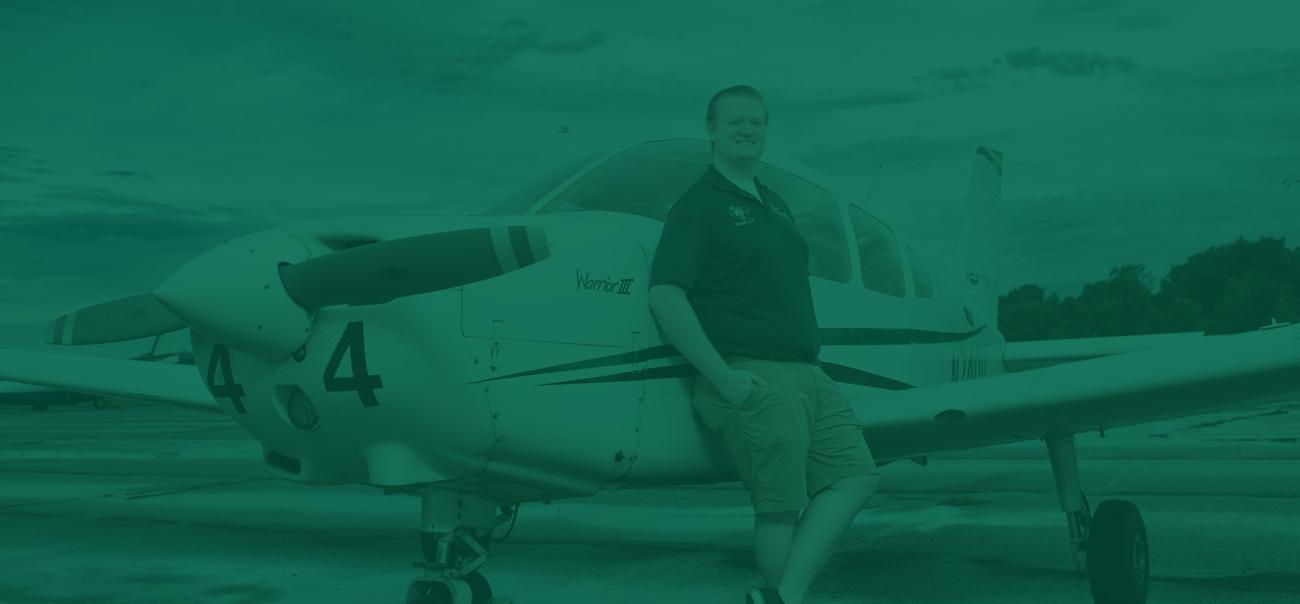 Aviation student poses with an airplane