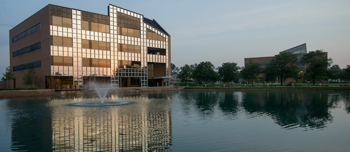 Building behind pond with fountain 