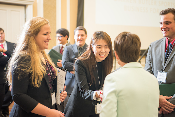 Attendees shake hands at a career fair