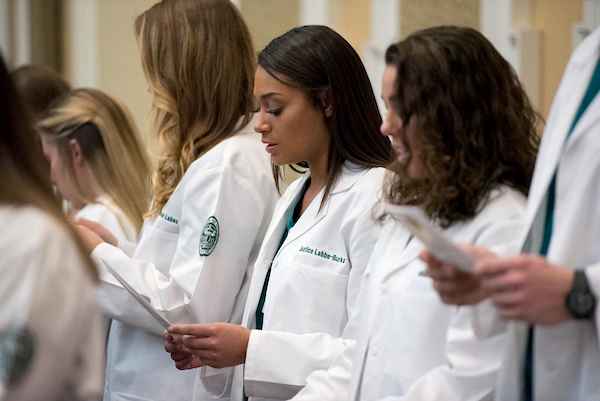 Doctors line up at a white coat ceremony