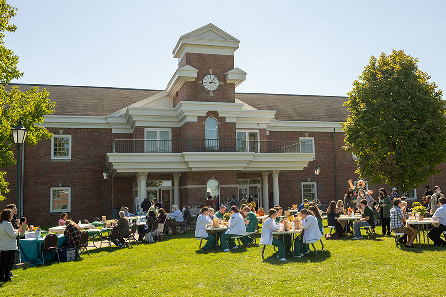 Students share a meal outside a building on Eastern campus