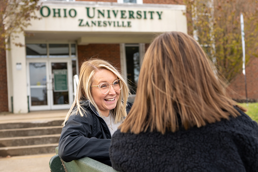Two students talk outside a building on the Zanesville campus