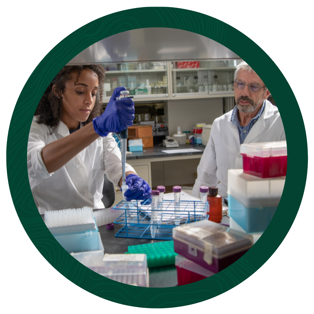 Student and professor in lab using lab tools.