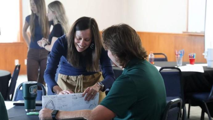 Teacher and student working at a table.
