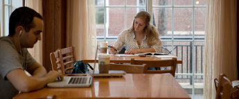 students sitting at tables working on homework