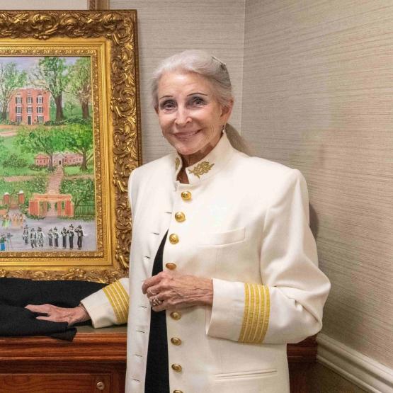 Artist Betsy Ross Koller standing next to her framed print, Love in Bloom.