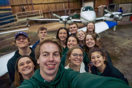 Group photo of students in front of planes.