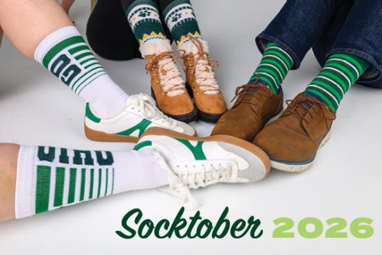 Three people sitting with feet put into circle wearing different OHIO socks.