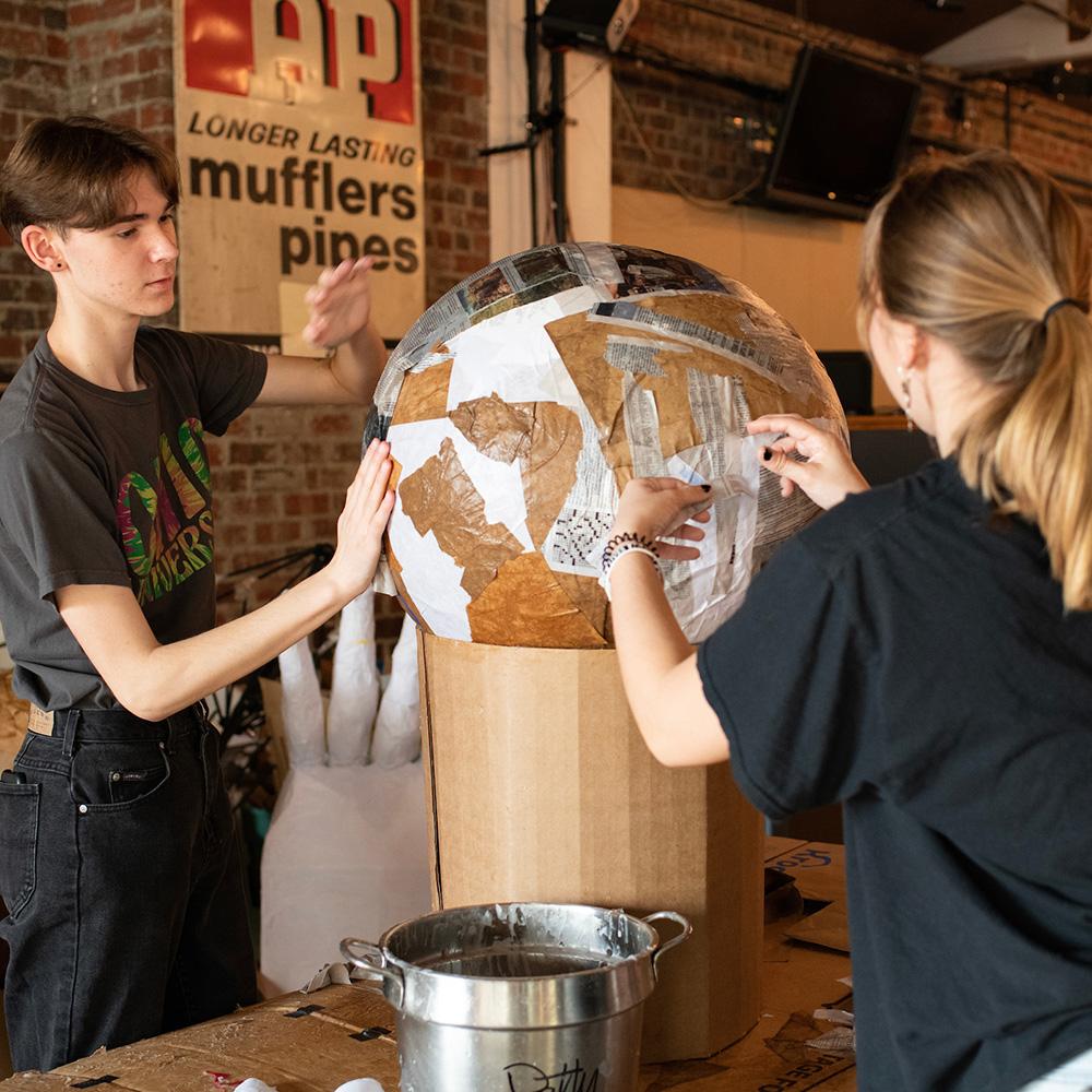 Students make a paper mache globe.