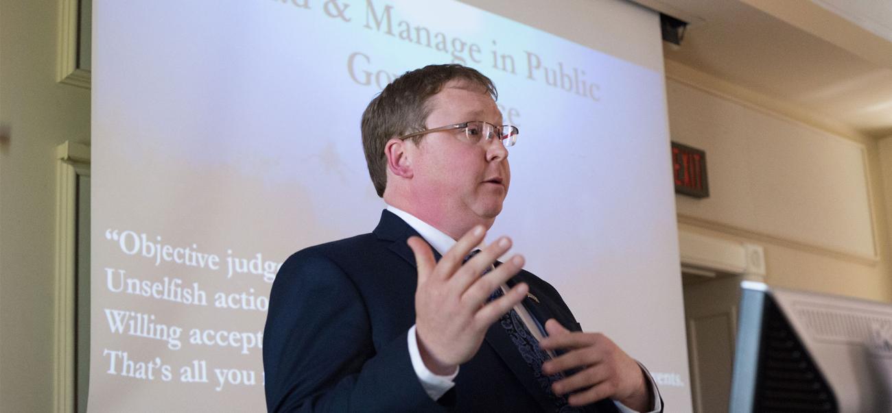 Man in front of screen leading an mpa program lecture