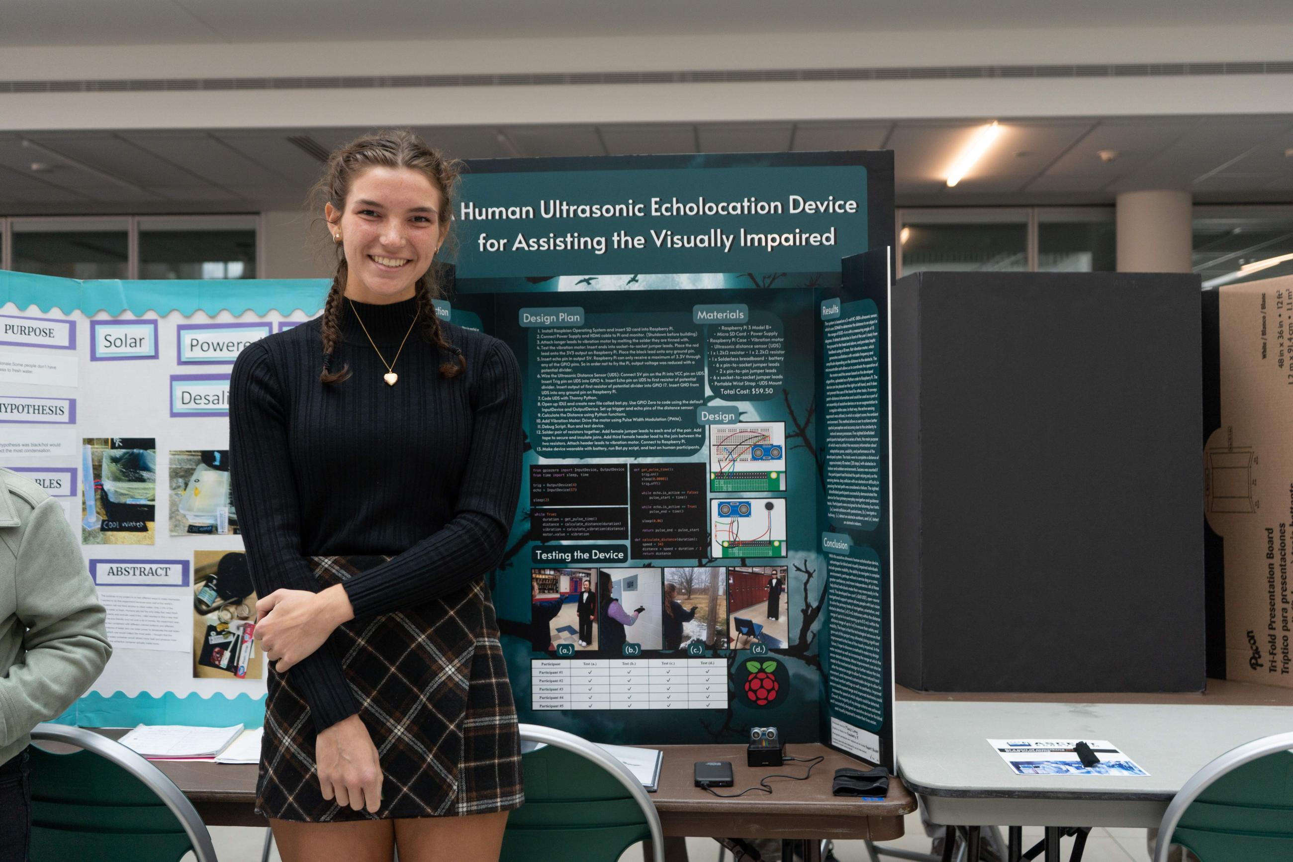 Student posing in front of her science project